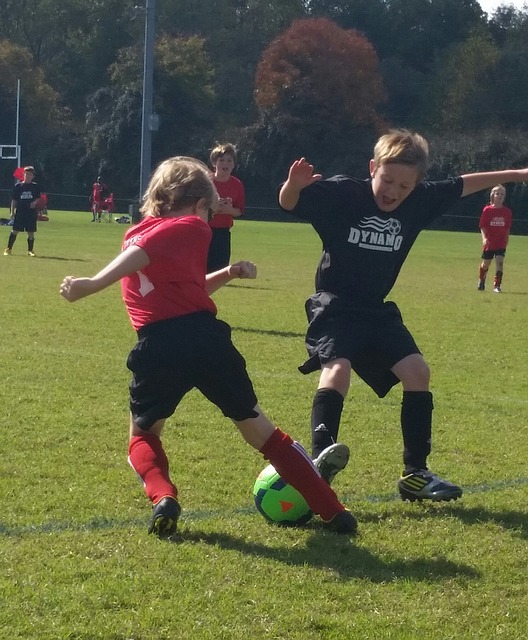 少年サッカーでオフェンスの選手が、ディフェンダーがボールを取りに来たところ（軸足に重心が乗っている瞬間）をインサイドの切り返しでかわそうとしている風景