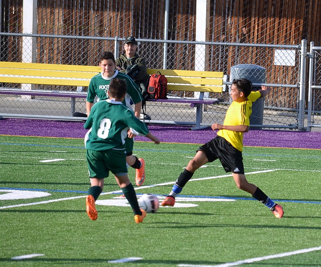中学生年代のサッカーの試合でオフェンスの選手がボールコントロールをしている瞬間の風景