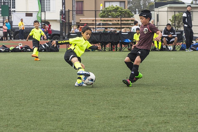 少年サッカーの試合でオフェンスの選手がボールを切り返してディフェンダーをかわしている場面
